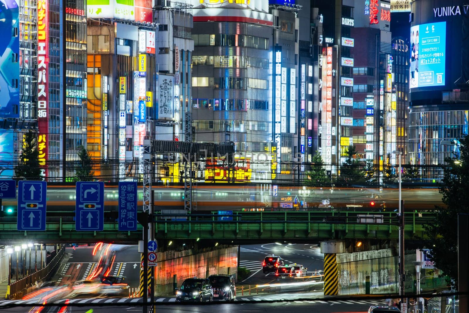TOKYO, JAPAN, SEPTEMBER 16 2024: Train and traffic in Tokyo’s busy Shinjuku neighborhood at night in Japan