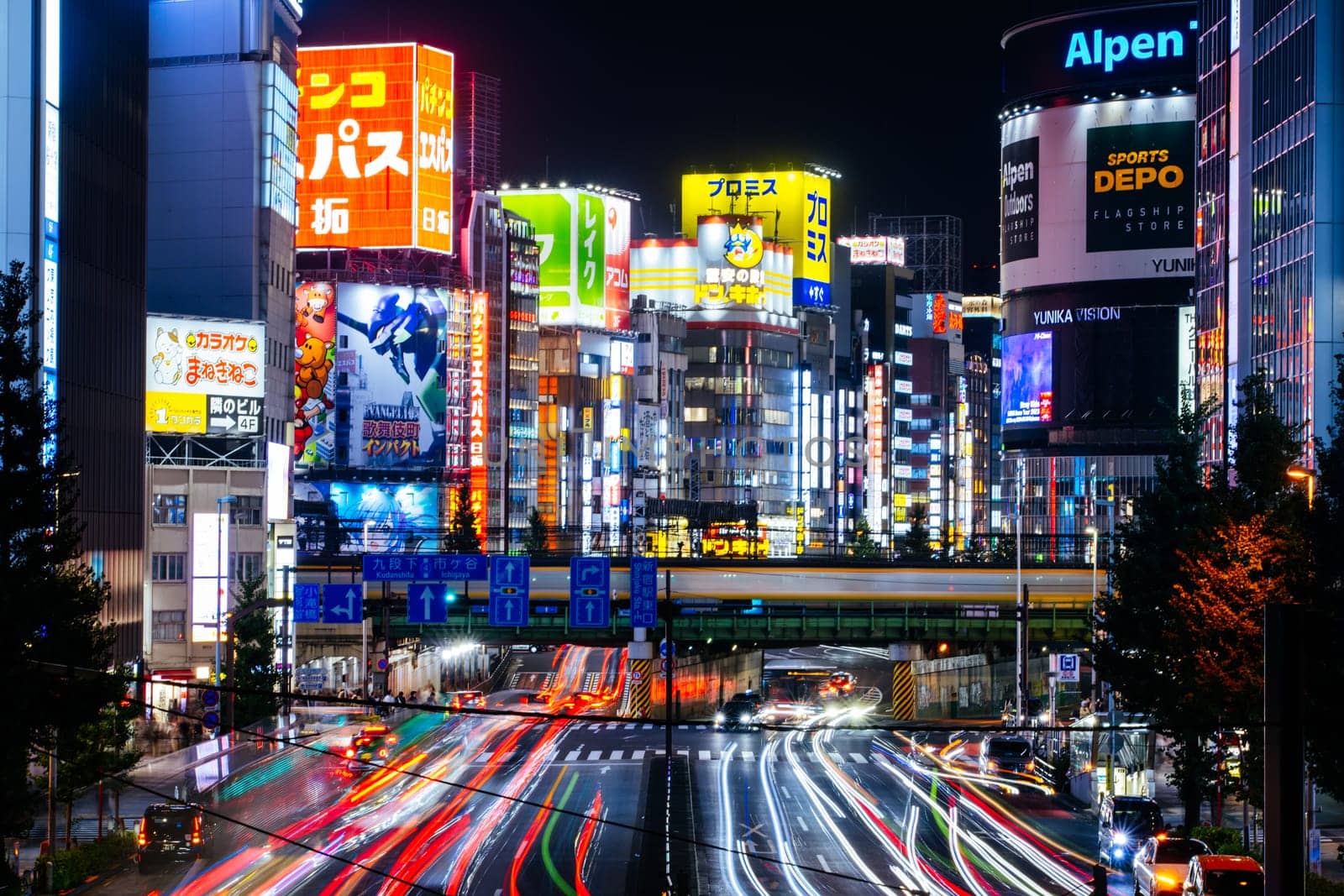TOKYO, JAPAN, SEPTEMBER 16 2024: Train and traffic in Tokyo’s busy Shinjuku neighborhood at night in Japan