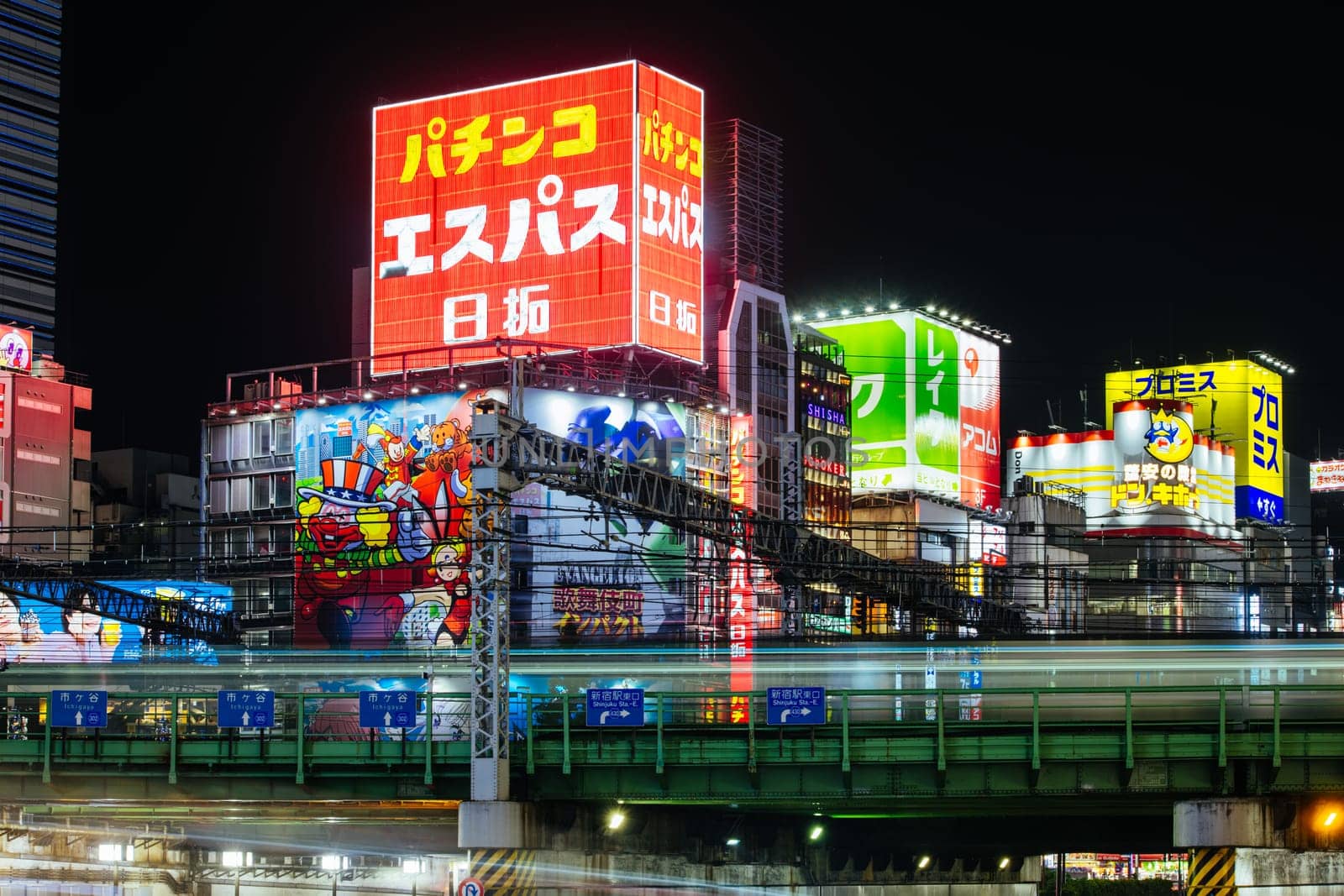 TOKYO, JAPAN, SEPTEMBER 16 2024: Train and traffic in Tokyo’s busy Shinjuku neighborhood at night in Japan