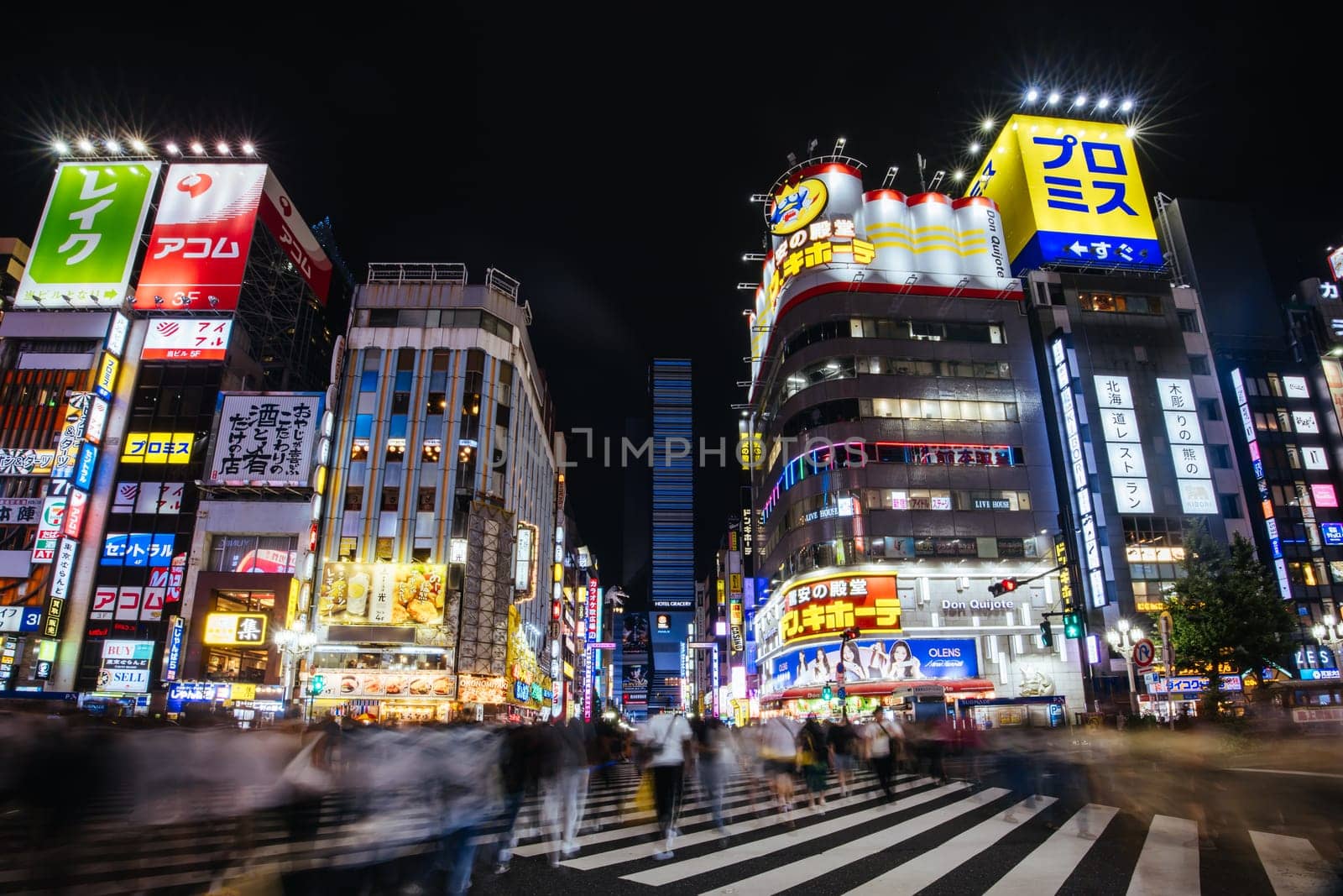 TOKYO, JAPAN, SEPTEMBER 16 2024: Neon signs illuminate with traffic in Tokyo’s busy Shinjuku neighborhood at night in Japan