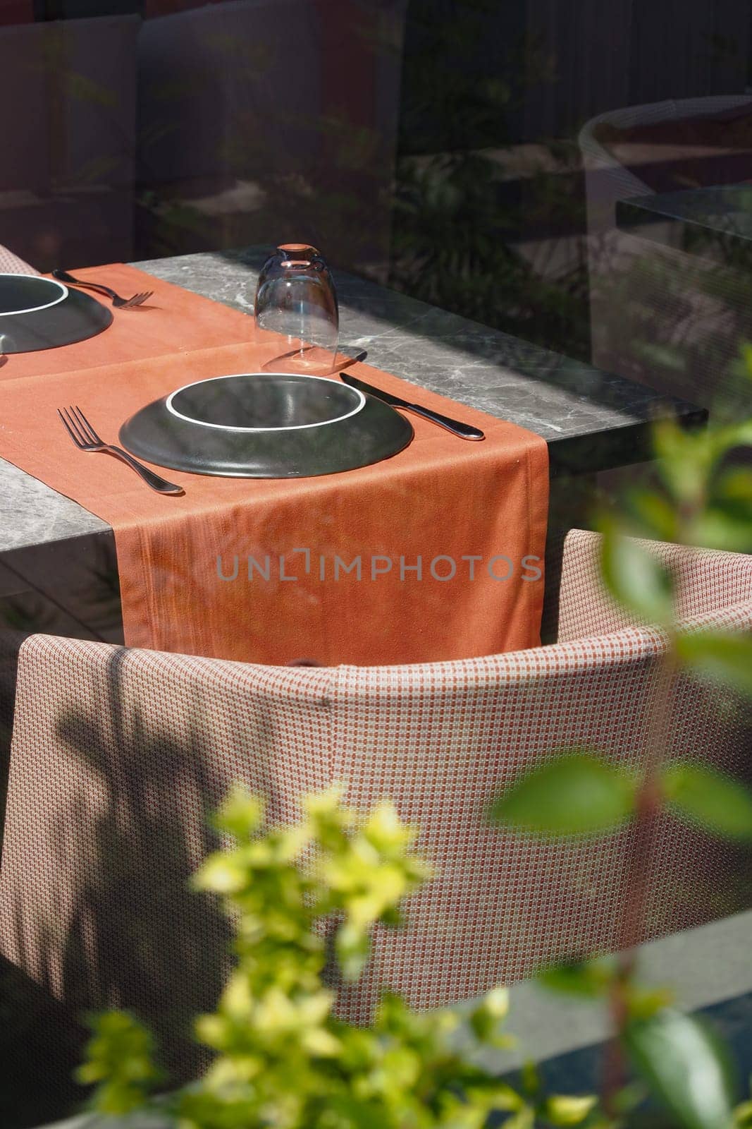A beautifully designed outdoor dining table set positioned perfectly amidst rich, lush greenery