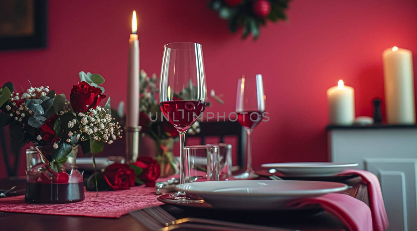 Festive table setting with candles and arrangement of beautiful red flowers. Holiday concept. High quality photo