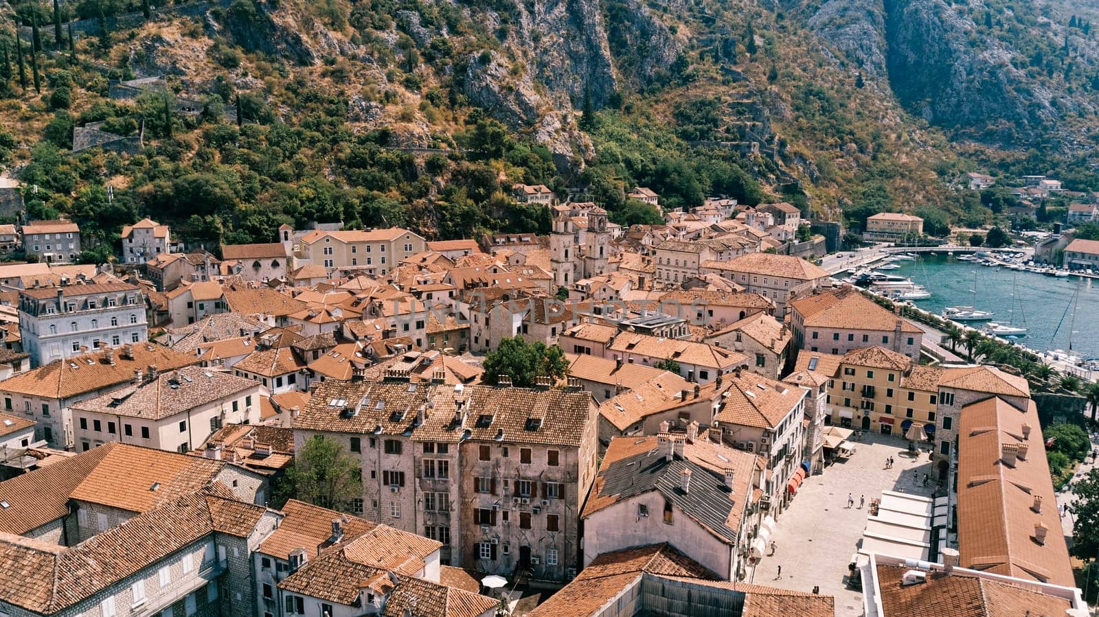 Narrow streets and small squares with old stone houses with red roofs. Kotor, Montenegro. Drone. High quality photo