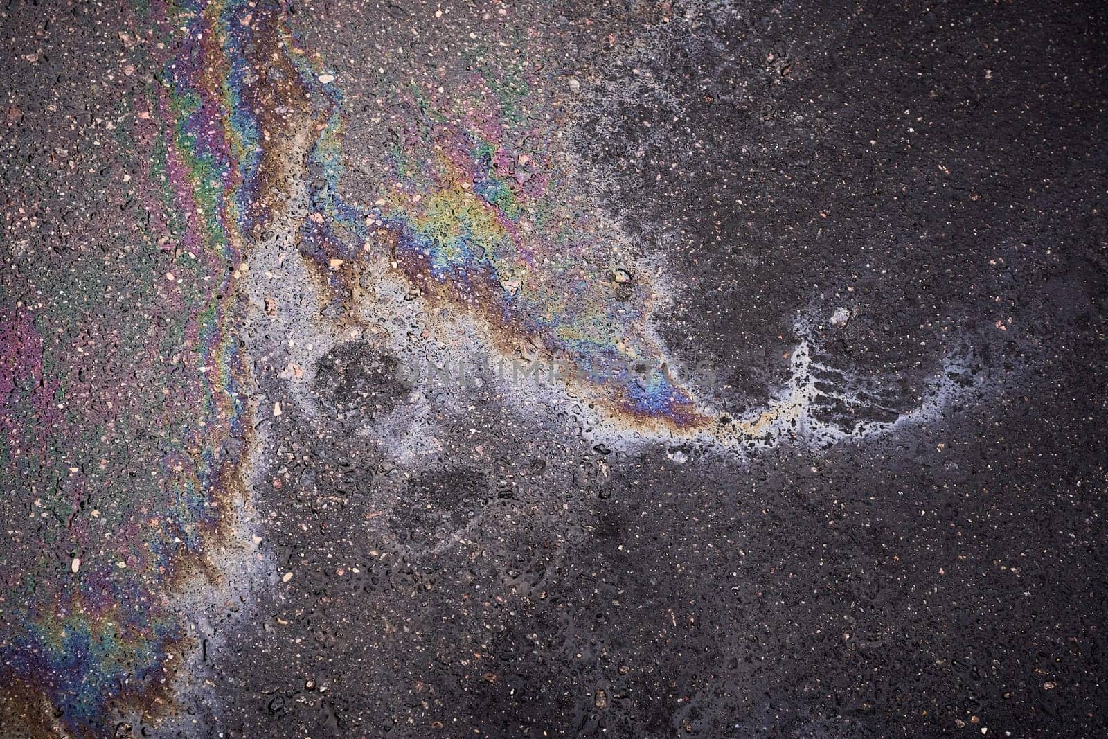 Gasoline or oil spill on asphalt creating rainbow color pattern