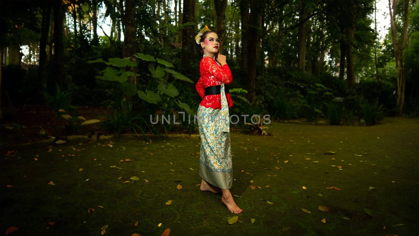 a traditional dancer called ronggeng stands with an expression full of beauty and beauty in a magical forest in the afternoon