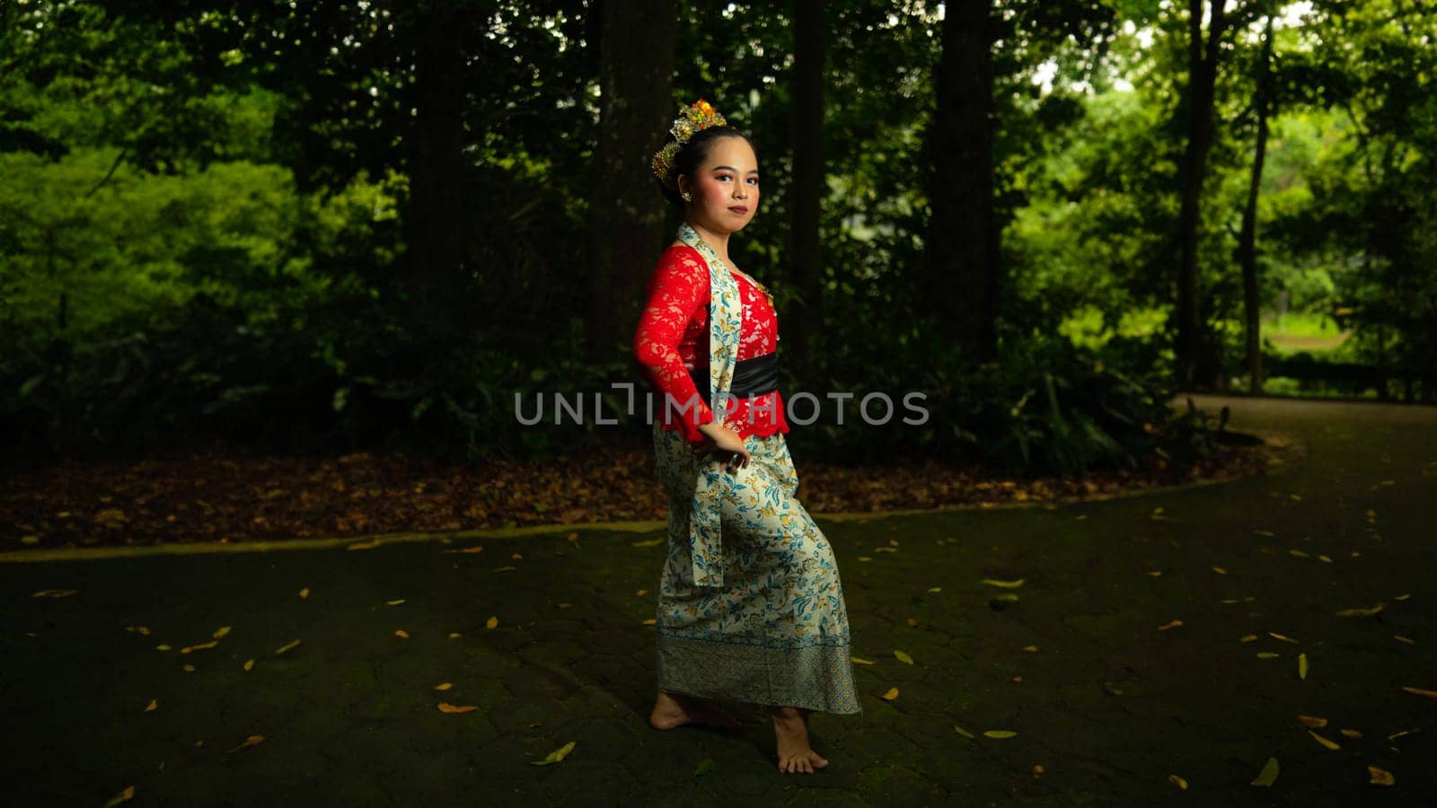 Traditional Javanese dancers wear red costumes that are full of details and ornaments depicting natural elements and symbols of Sundanese beliefs in the costumes