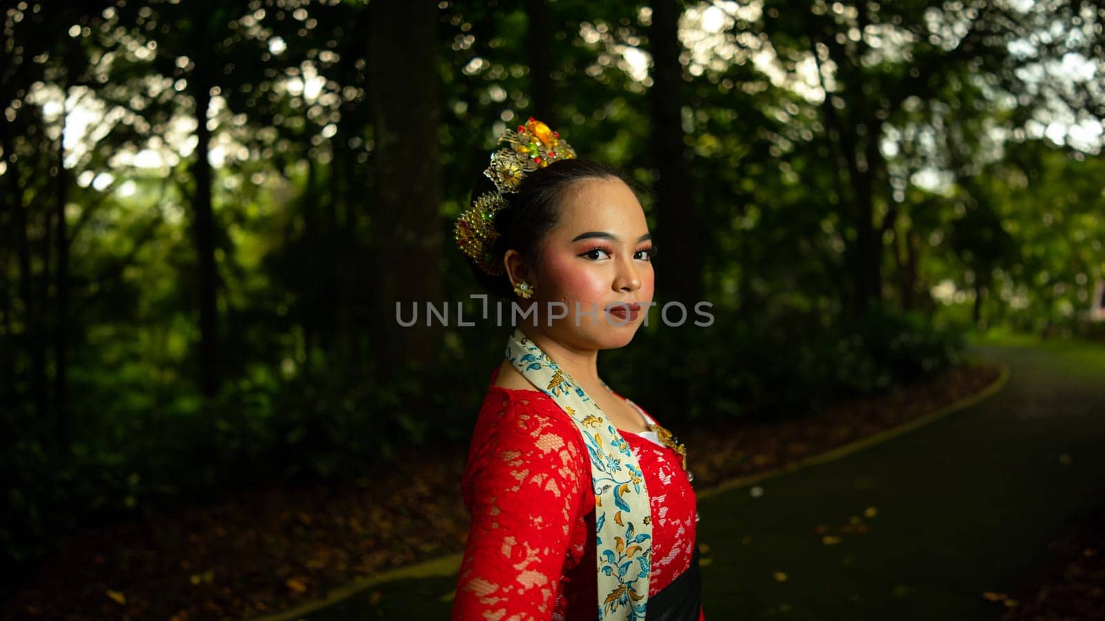 Traditional Javanese dancers wear red costumes that are full of details and ornaments depicting natural elements and symbols of Sundanese beliefs in the costumes