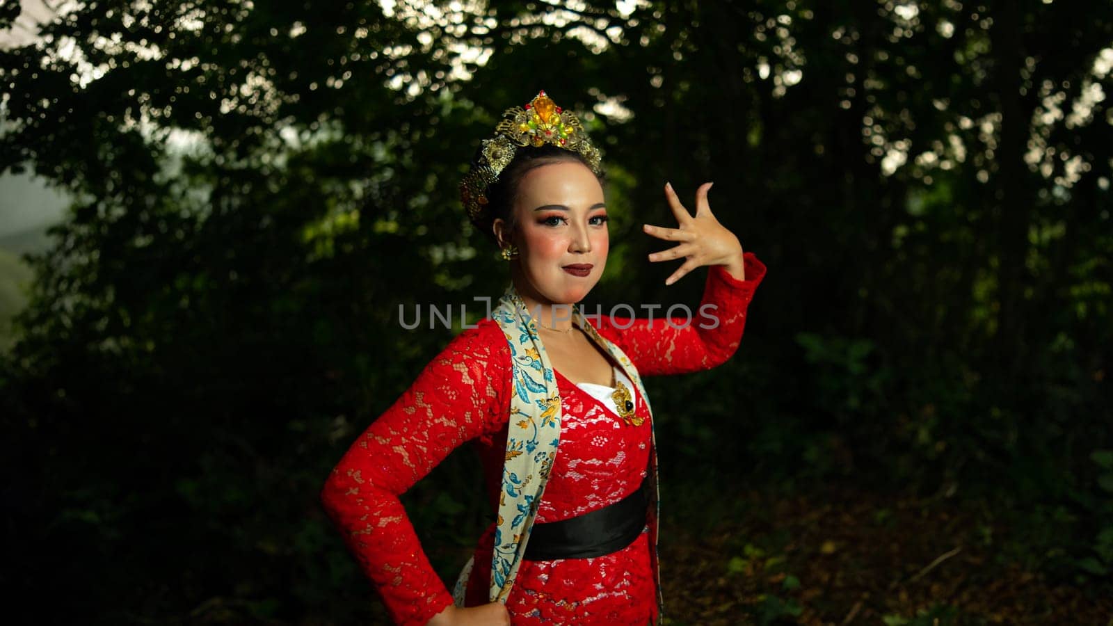 a traditional Indonesian dancer performs in a traditional ceremony and cultural festival in the forest in the morning