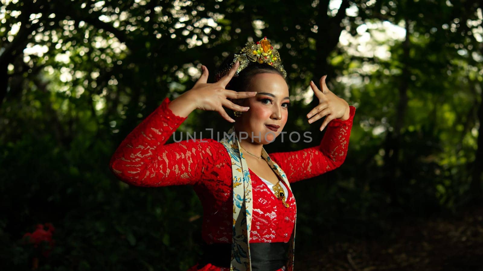 a traditional Indonesian dancer performs in a traditional ceremony and cultural festival in the forest in the morning