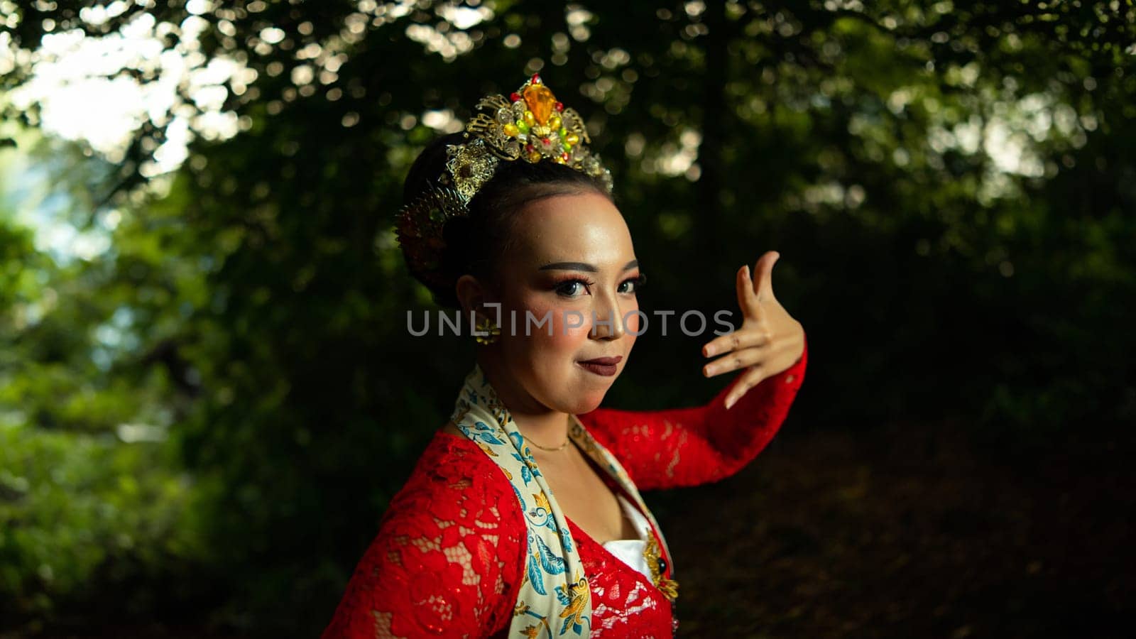 a traditional Indonesian dancer performs in a traditional ceremony and cultural festival in the forest in the morning