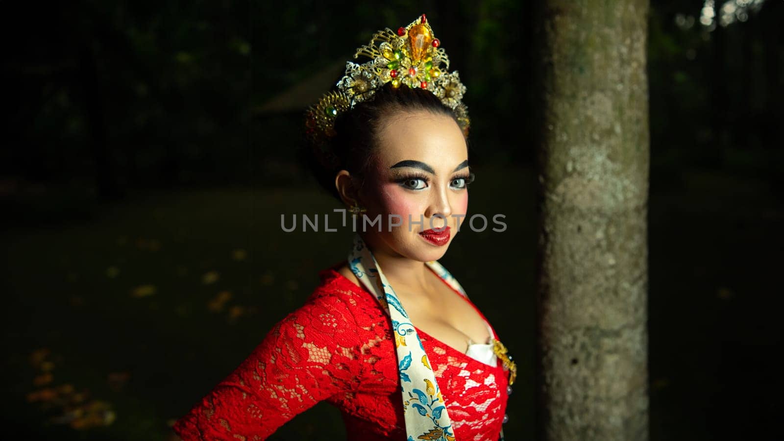 Indonesian traditional dancers wear red costumes with gold crown decorations which are very majestic when in the forest in the morning