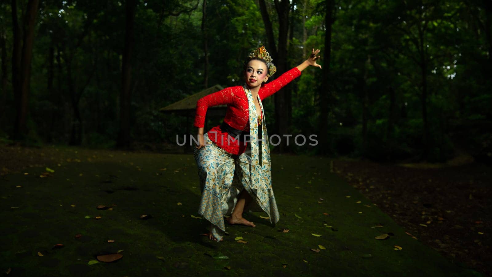 Indonesian traditional dancers wear red costumes with gold crown decorations which are very majestic when in the forest in the morning