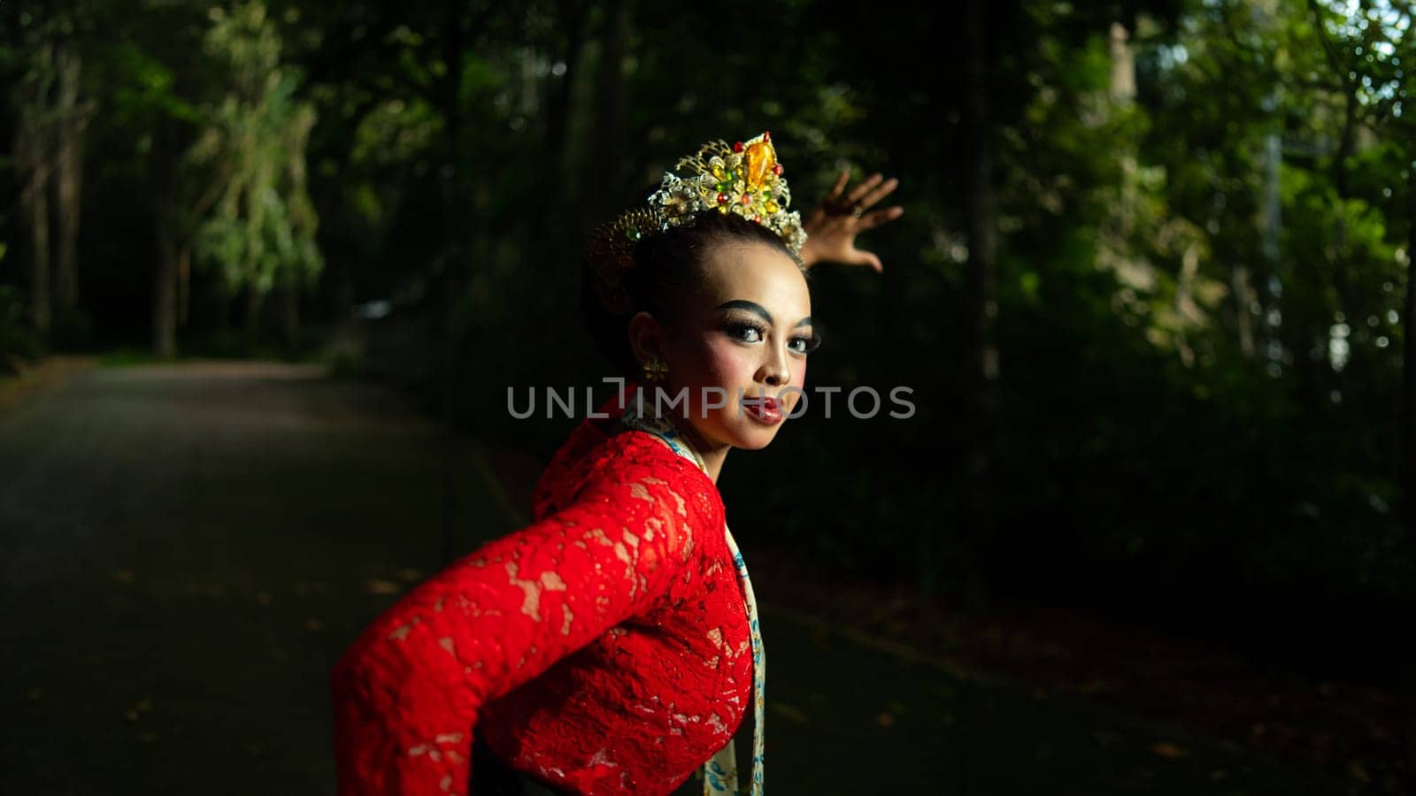 Indonesian traditional dancers wear red costumes with gold crown decorations which are very majestic when in the forest in the morning