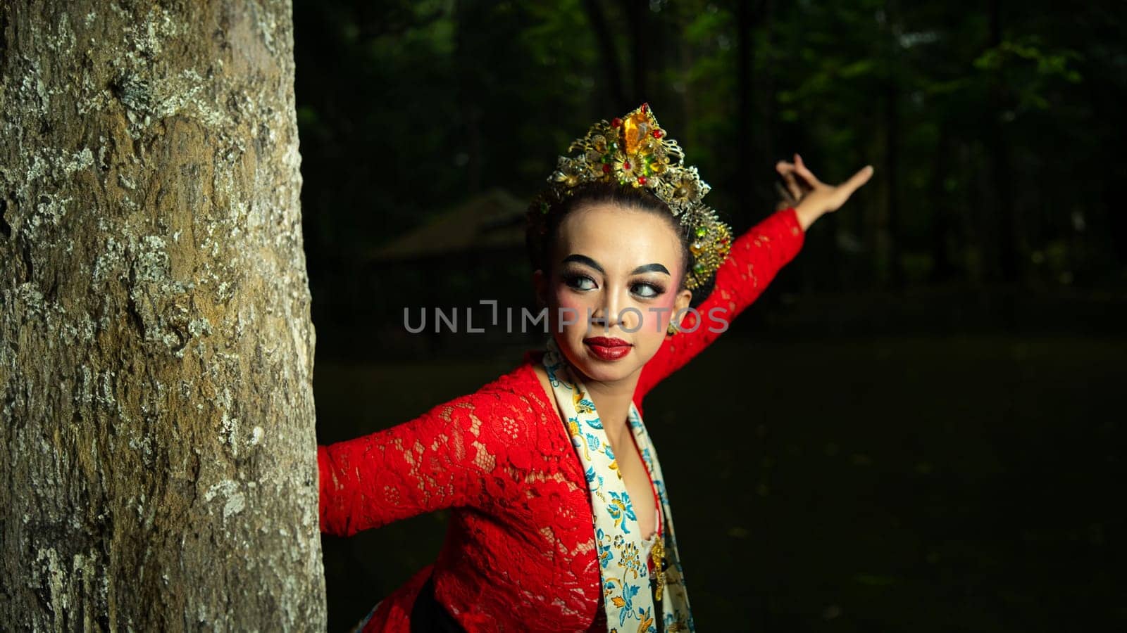 Indonesian traditional dancers wear red costumes with gold crown decorations which are very majestic when in the forest in the morning