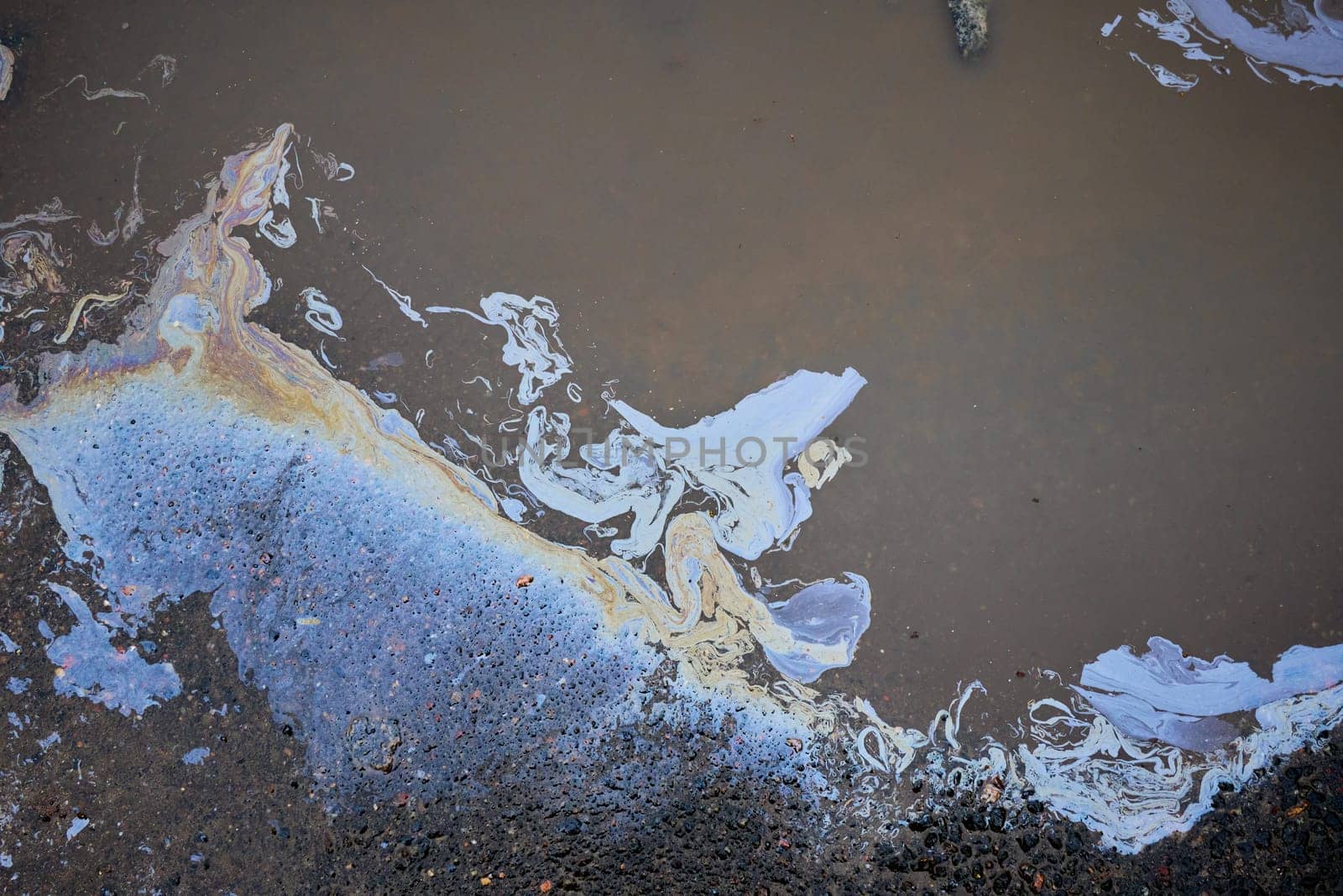 Gasoline or oil polluting water and creating colorful patterns on the surface.