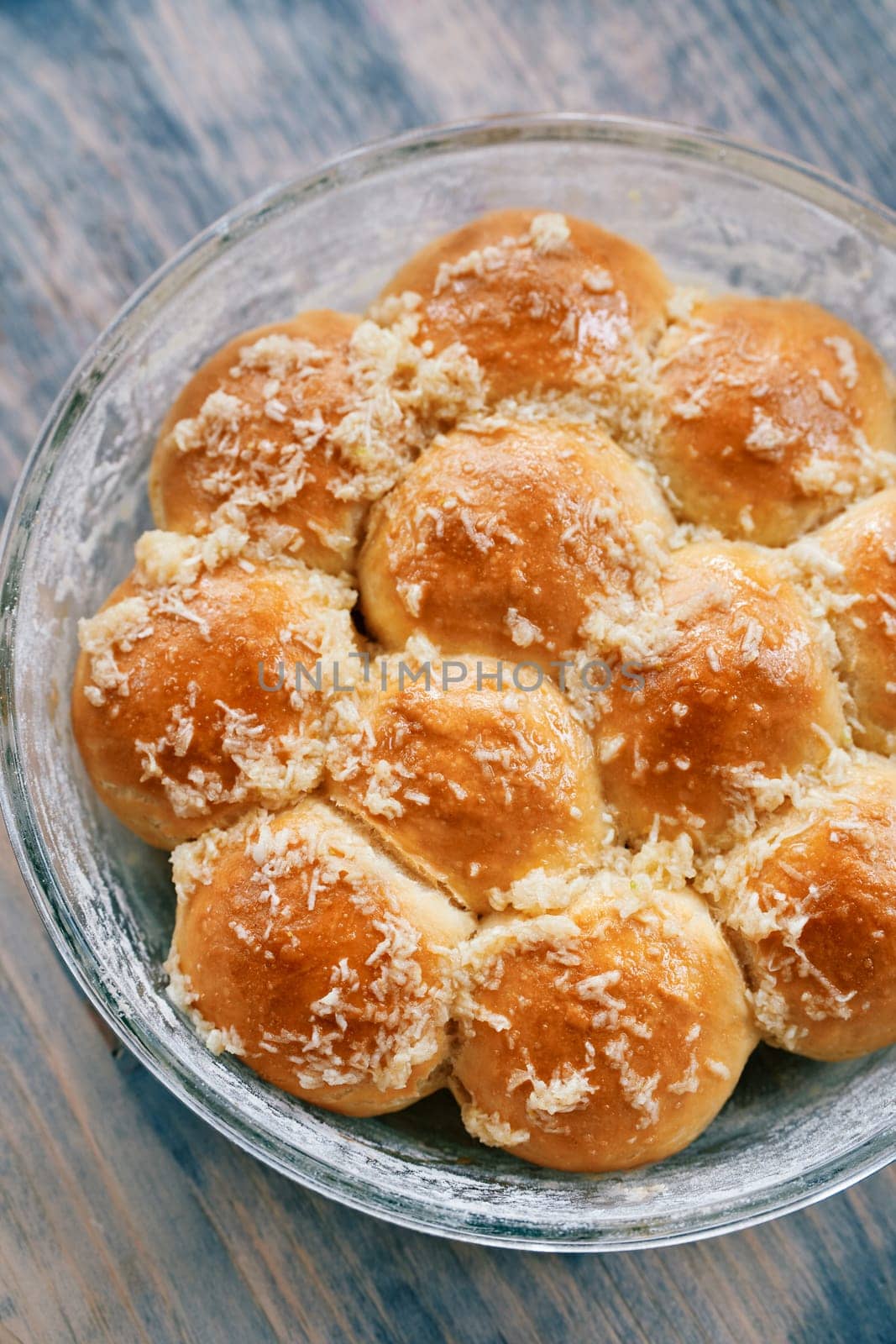 Glass dish with ruddy donuts sprinkled with grated garlic on the table. High quality photo