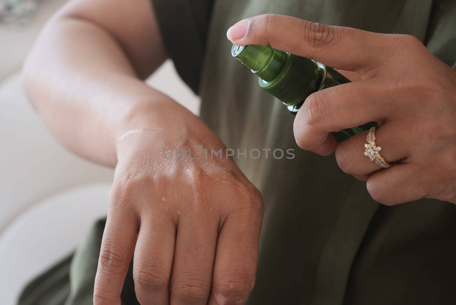 Person Applying Natural Skincare Spray to Their Hands for Moisturization.