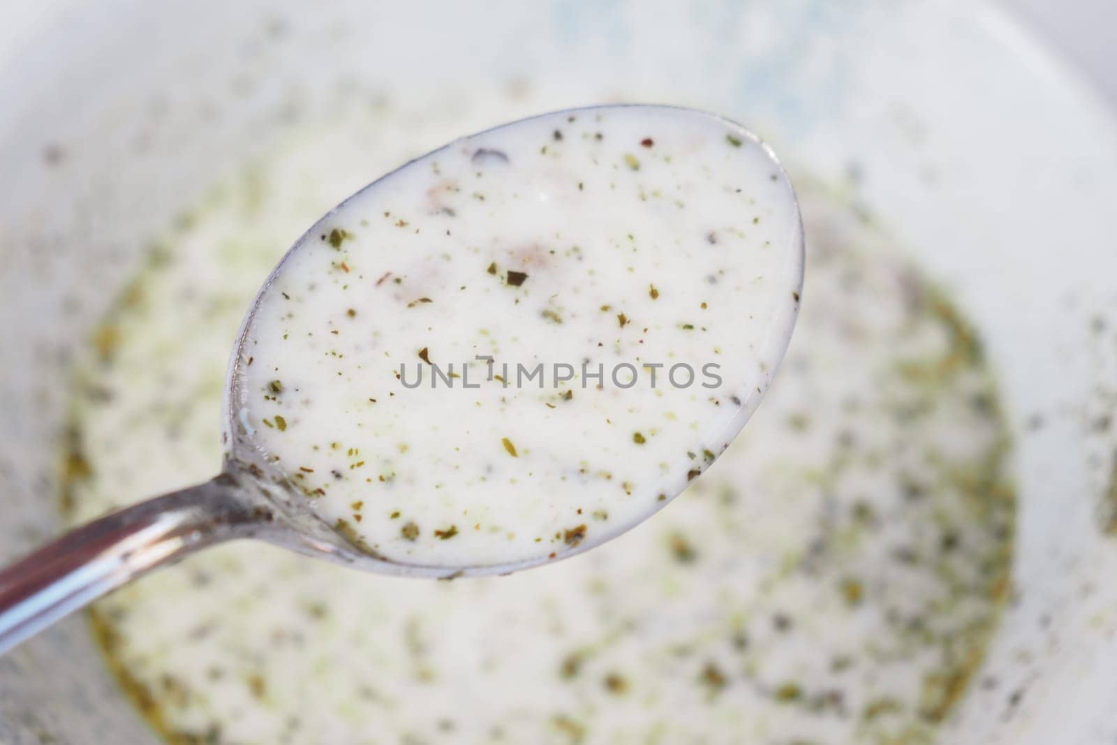 woman eating yogurt soup, traditional soup with chickpeas and mint