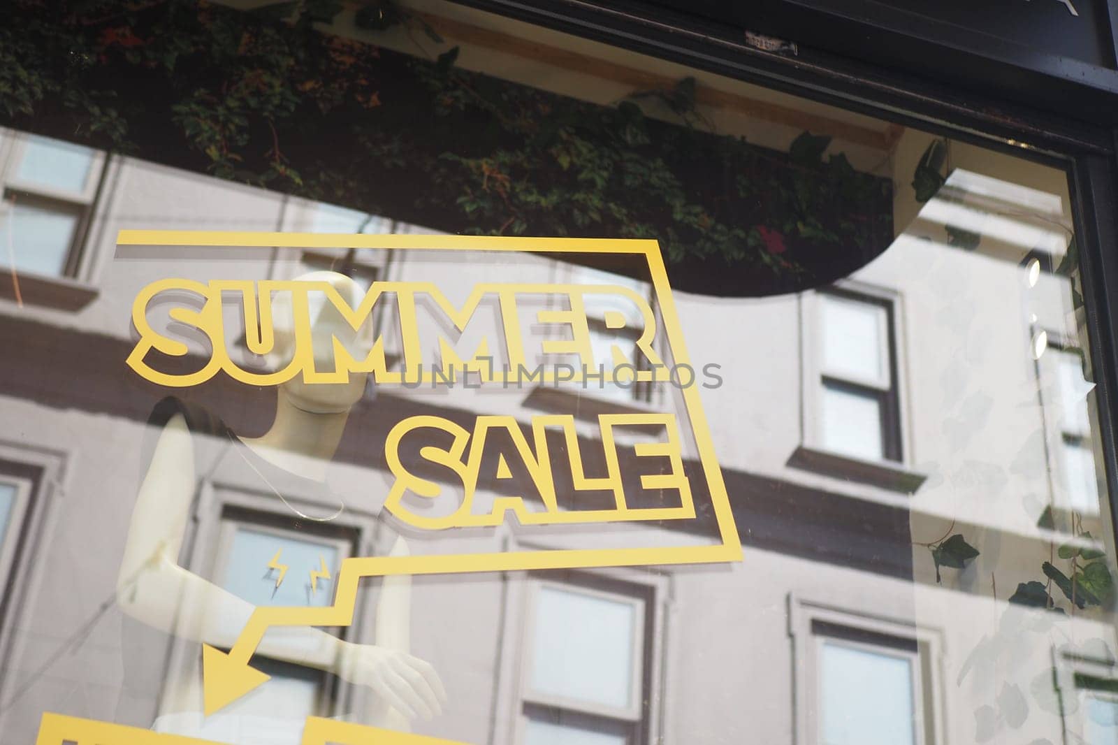 Large yellow Sale text letters on a glass wall obstruct a view inside the popular fashion store.