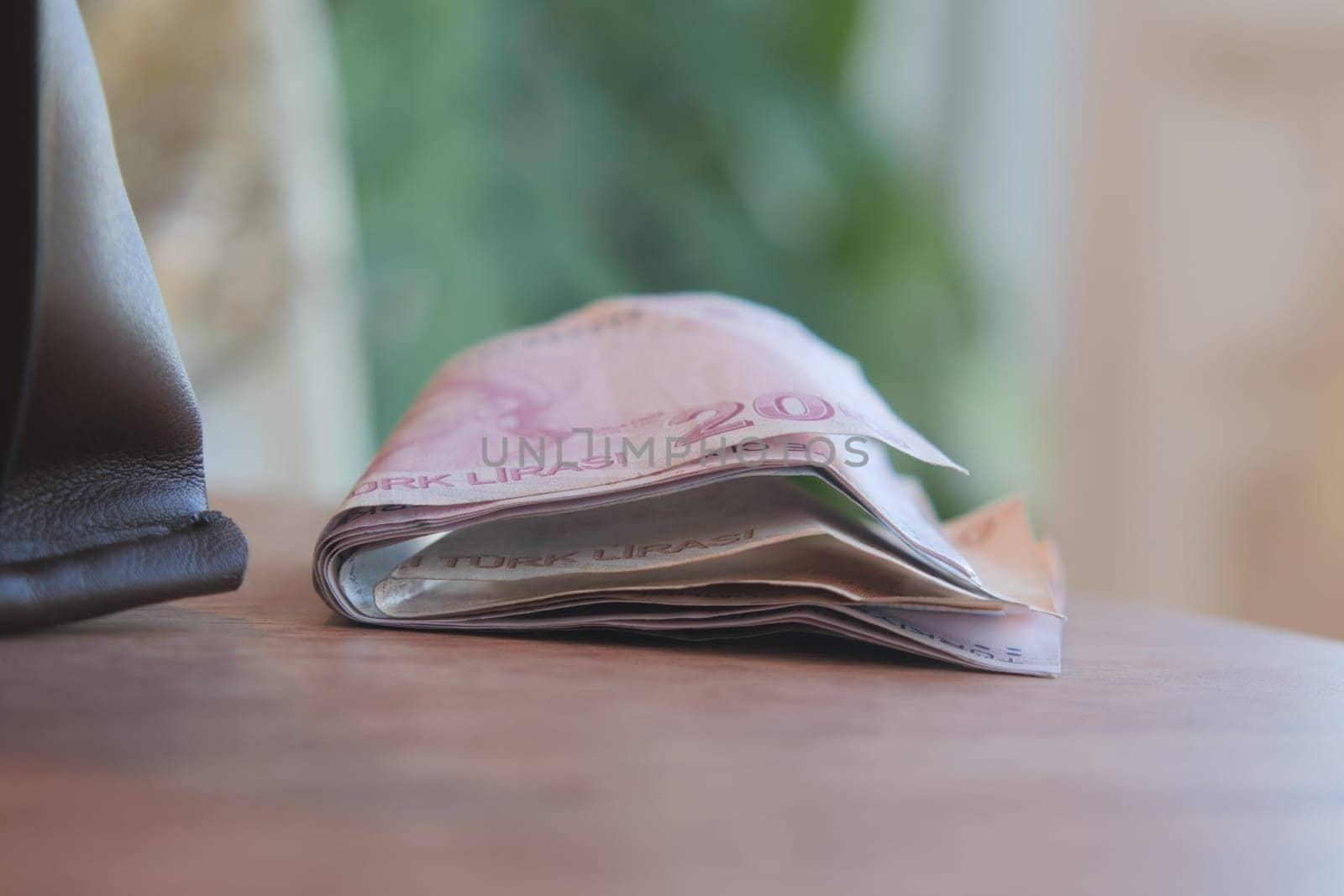 A closeup view of a stack of currency notes held together with a rubber band to stay organized