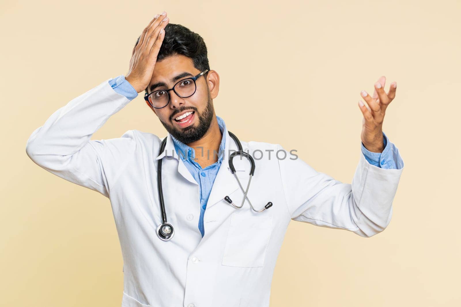 Indian young doctor cardiologist man feeling hopelessness and loneliness, nervous breakdown, loses, bad fortune, loss, unlucky news, fail. Arabian apothecary pharmacy guy isolated on beige background