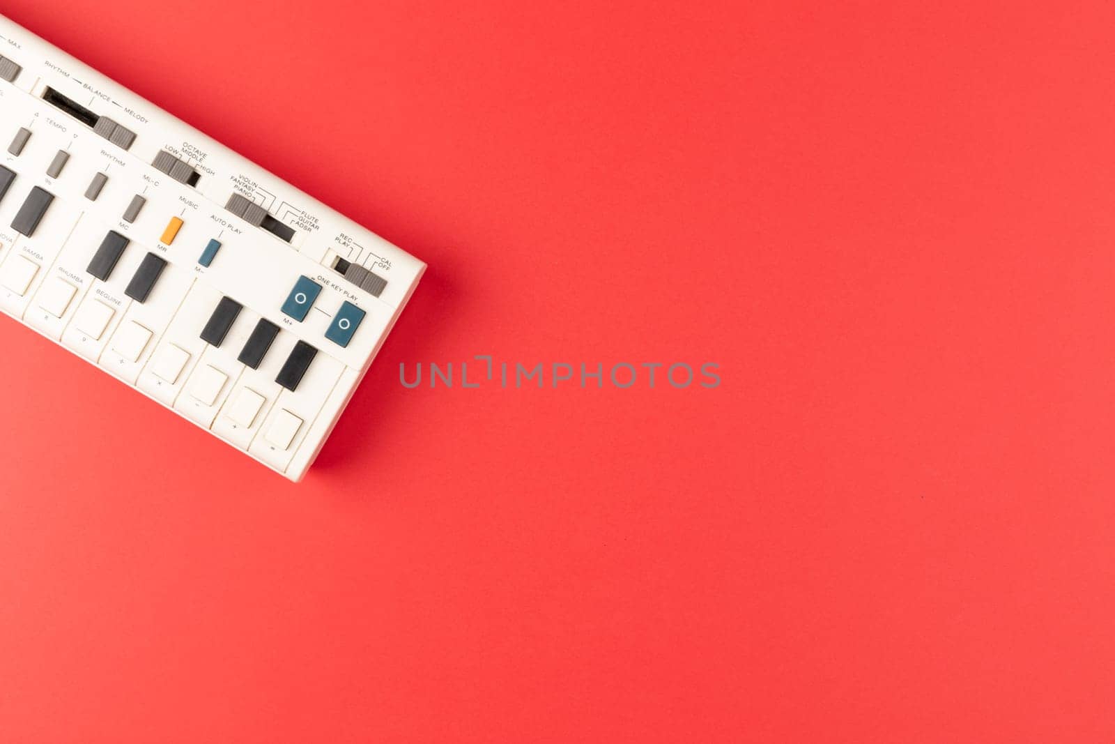 Vintage electronic keyboard synth piano on red background by TropicalNinjaStudio