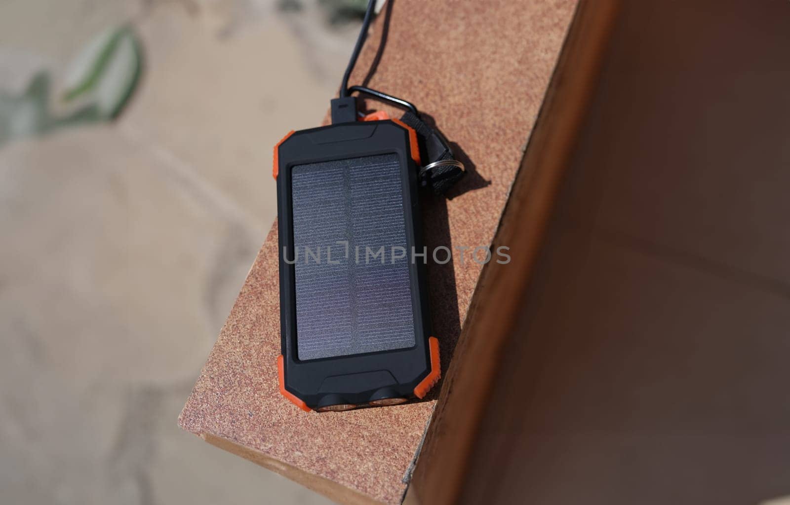 Solar power bank recharging by sunlight outdoor closeup. Environmental protection energy saving concept