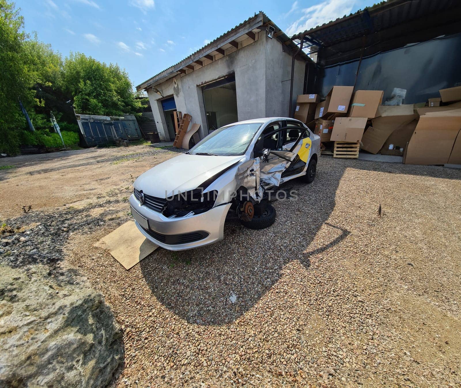 Tbilisi, Georgia - July 26, 2022: Broken gray Volkswagen sedan taxi car. Wrecked taxi car after side collision in parking lot.