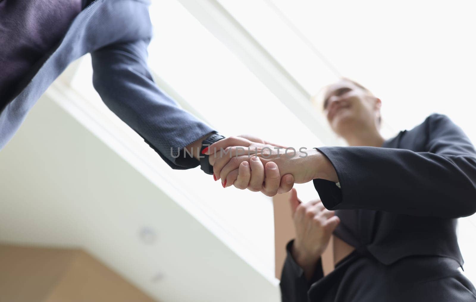 Businessman and woman shaking hands in office closeup. Welcome acquaintance greeting or gratitude gesture concept