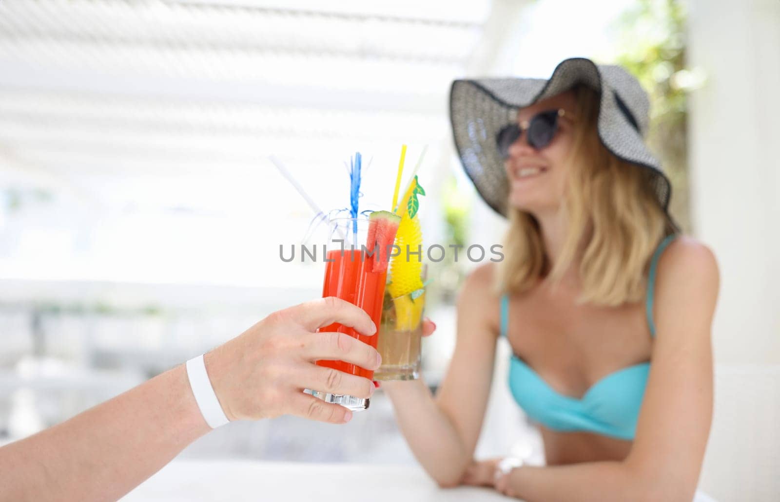 Happy couple in love toasting at resort in hotel. Summer refreshing cocktails concept