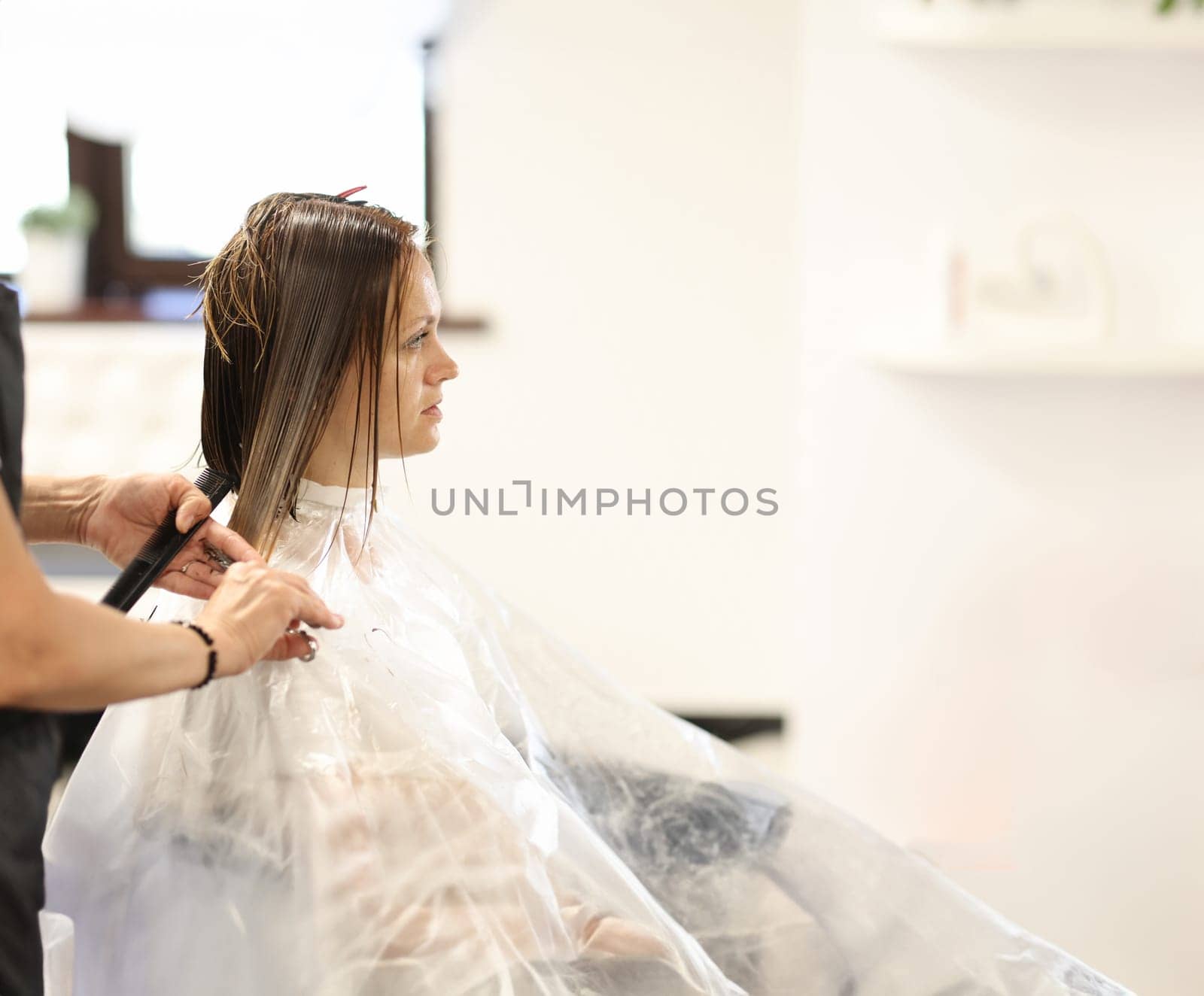 Hairdresser hands cut hair of client in beauty salon by kuprevich