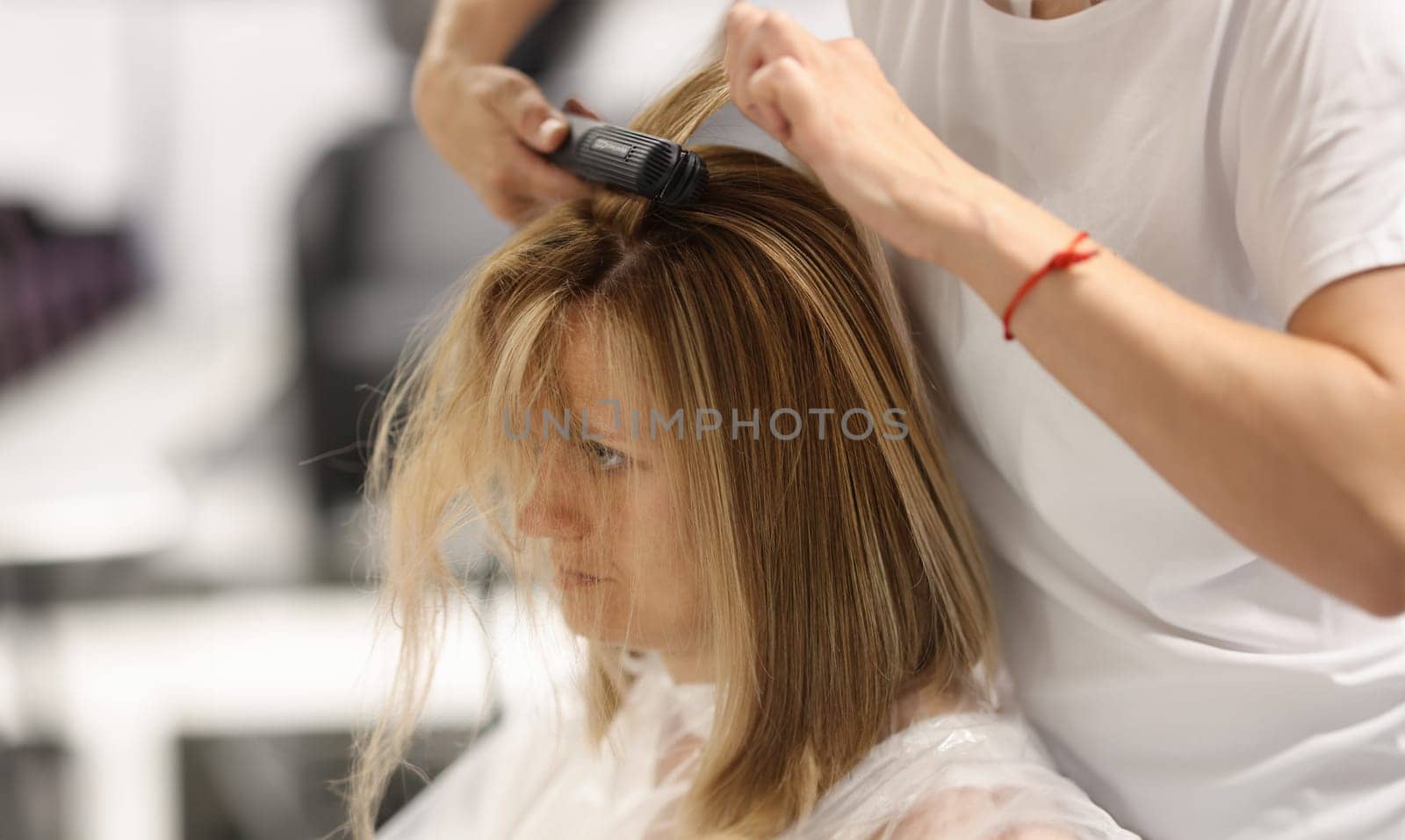 Pulling strands of hair with professional iron care by kuprevich
