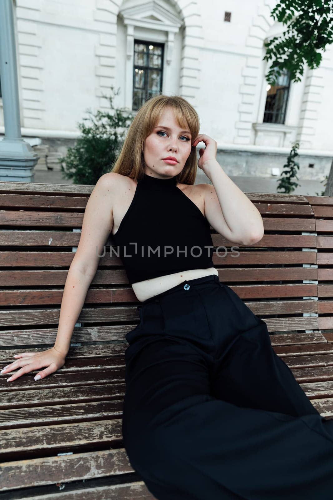 a relaxed woman a free woman sitting on a wooden bench on the street