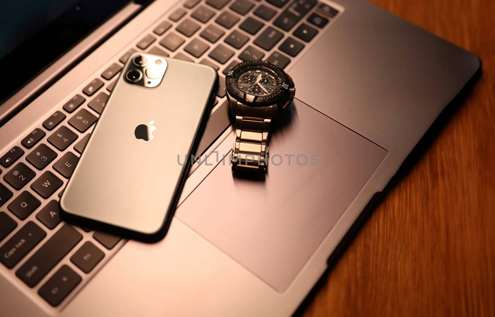 Tbilisi, Georgia - September 26, 2023: Modern smartphone apple watch on laptop keyboard. Modern stylish mobile and computer equipment