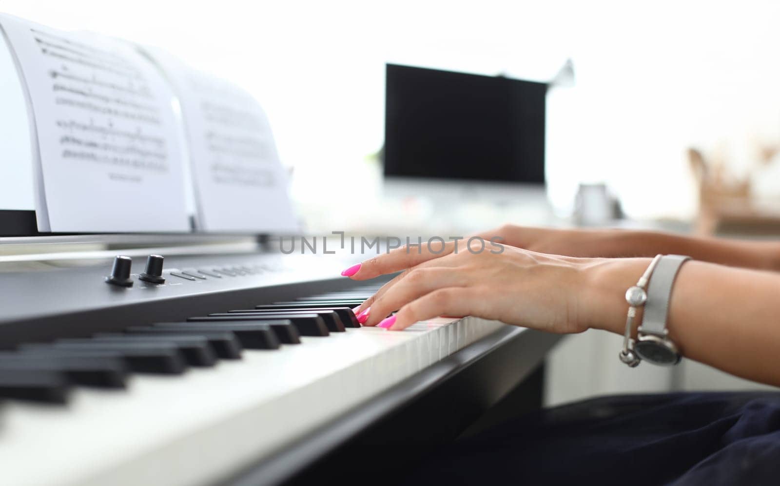 Female hand presses keys of synthesizer and learns to play. Piano lessons concept