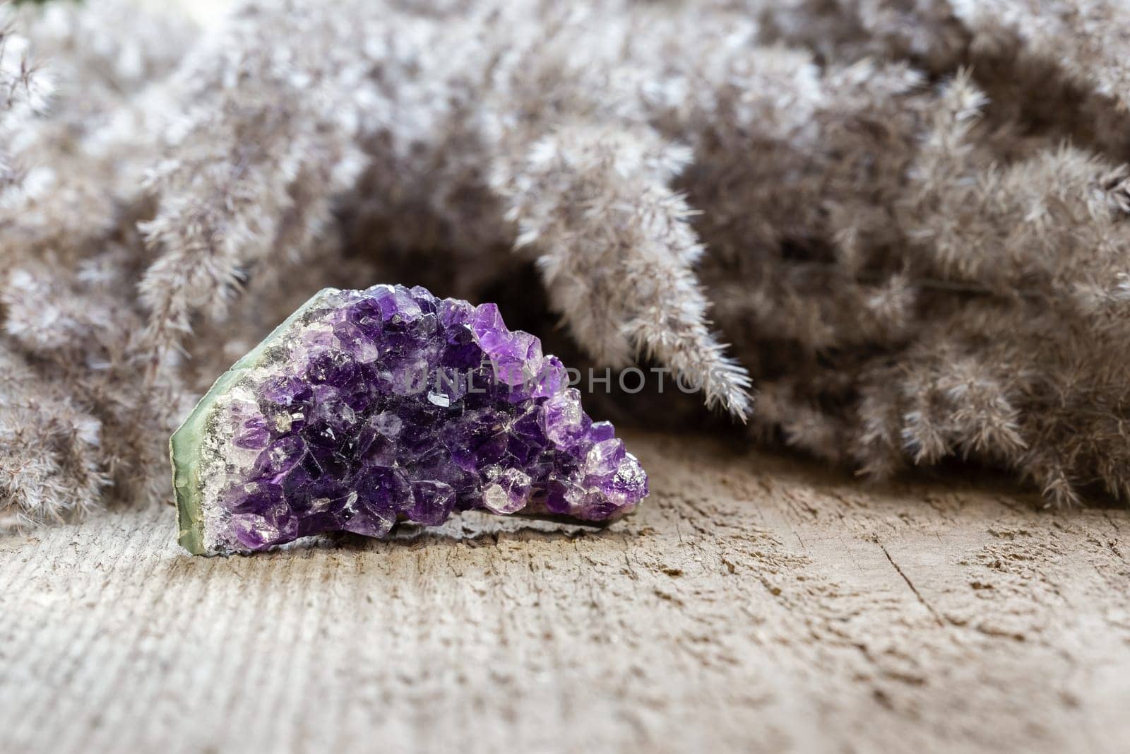 Amethyst crystal druzy a purple variety of quartz over wooden background. Healing crystal concept, amethyst is good for relieve anxiety and stress. Natural mineral stone collection