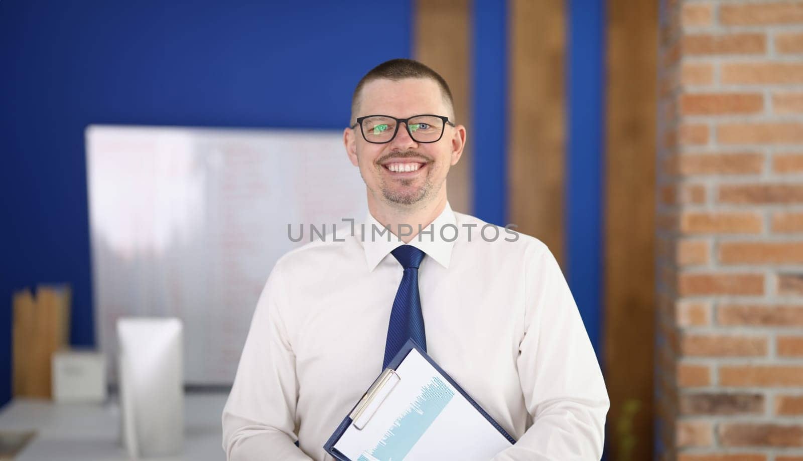 Portrait of young smiling businessman in glasses in office. Business consultant manager concept