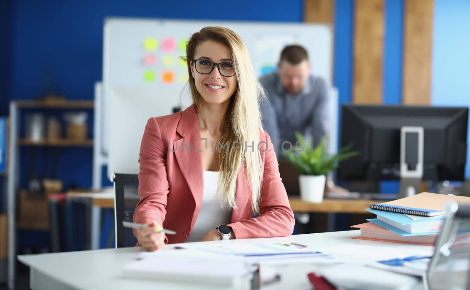 Portrait of smiling business woman in glasses in office. Beautiful business woman working with colleague