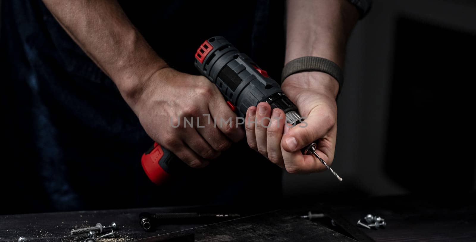 Man Holds Drill In Hands Close-Up
