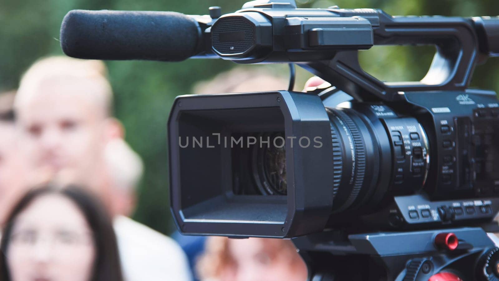 Professional videographer recording group of children on their first school day, capturing memories with a high quality camcorder