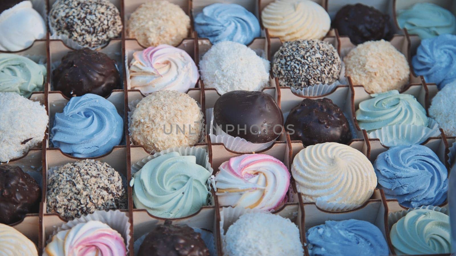 Delicious assorted marshmallows and chocolate candies arranged beautifully in a gift box, creating a tempting display of sweetness