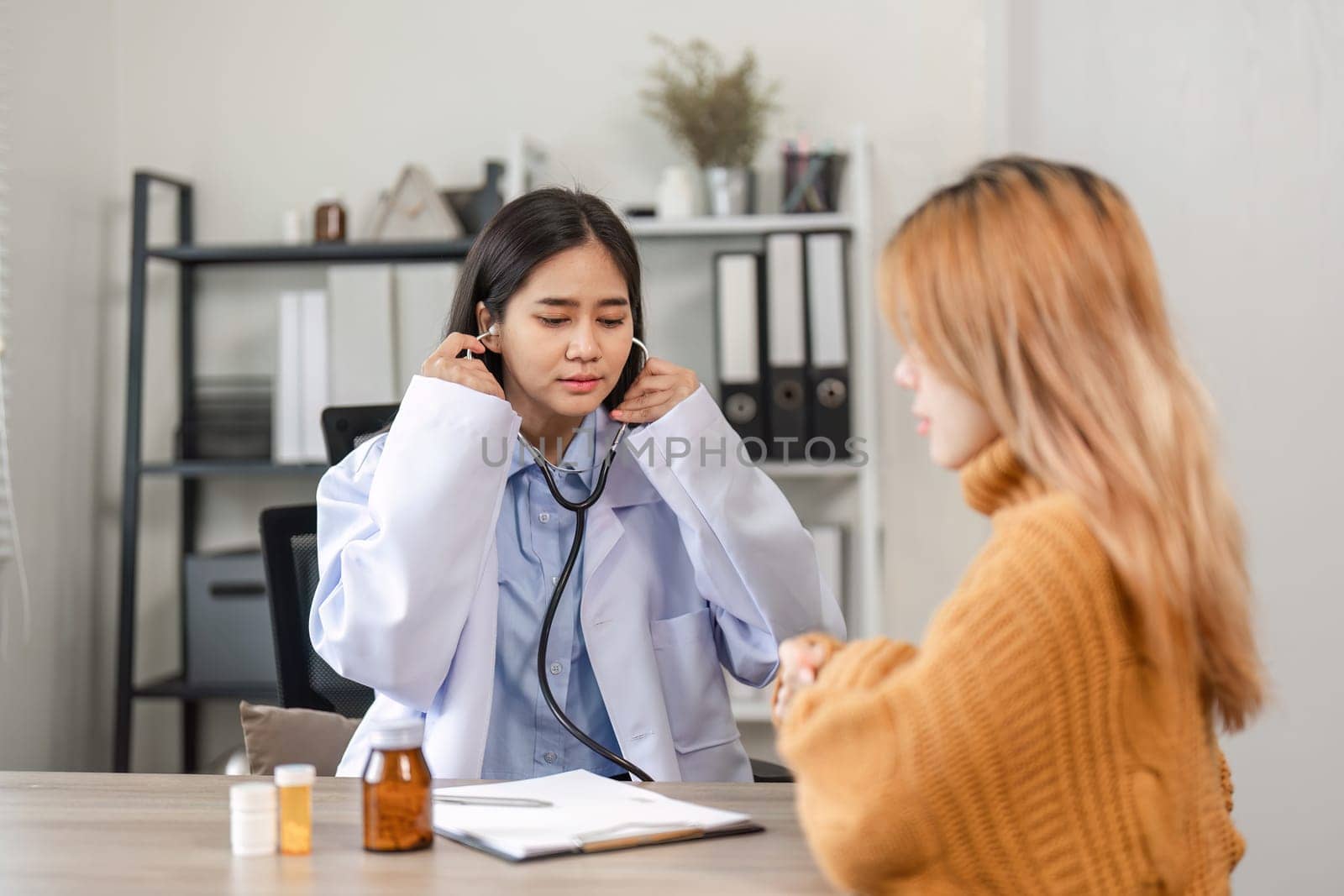 A doctor attentively listens to a patient, offering medical advice in a contemporary clinic environment.