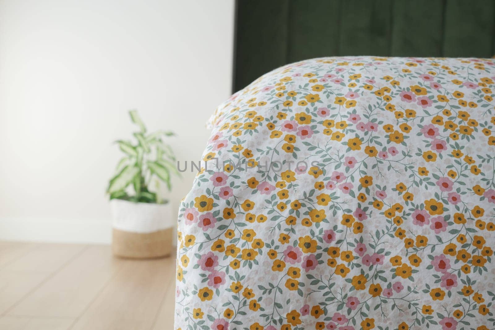 Charming and whimsical floral bedding featuring a modern plant accent in a cozy home setting
