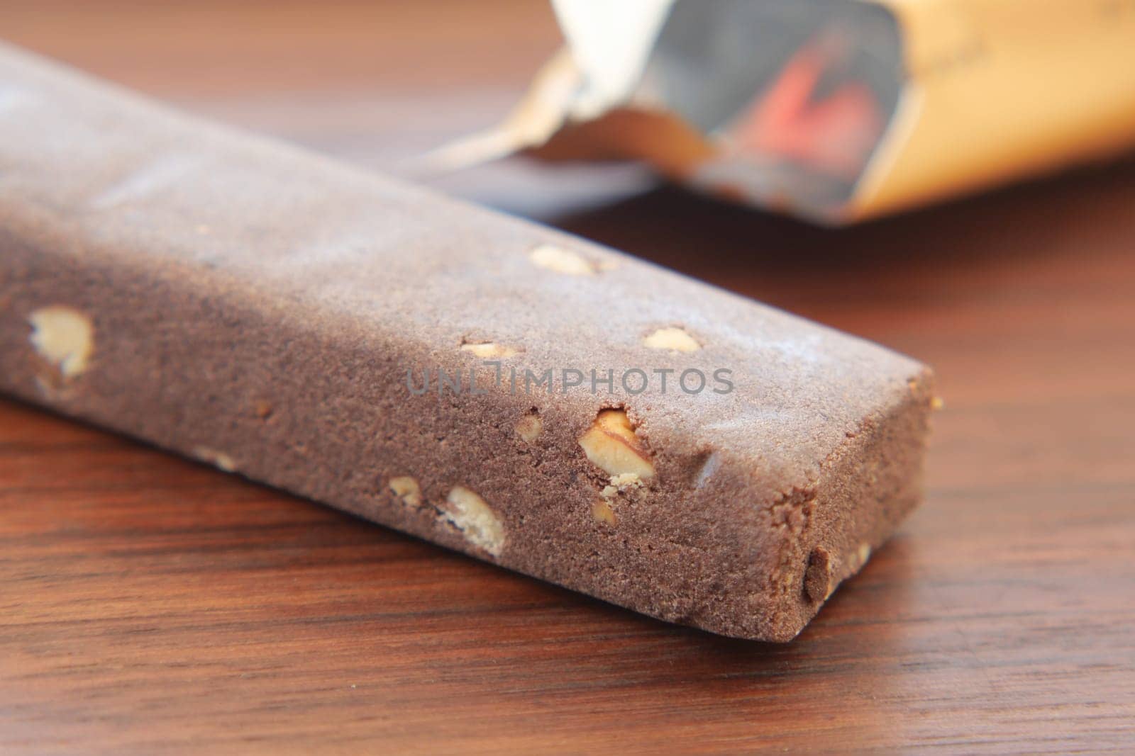A lavish and rich chocolate nut bar is beautifully resting on an elegant wooden surface