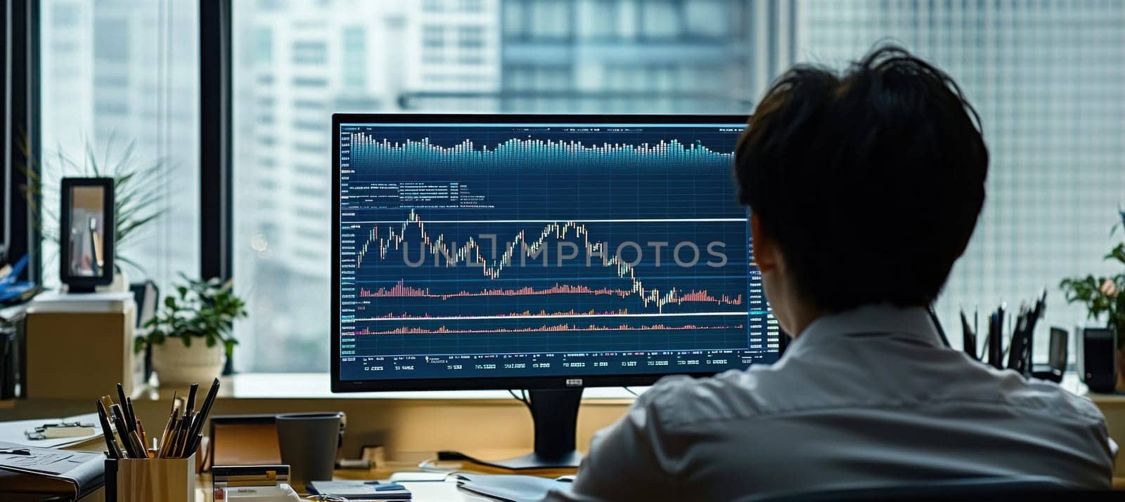 Stock trader analyzing cryptocurrency chart data on computer screen in office with city view