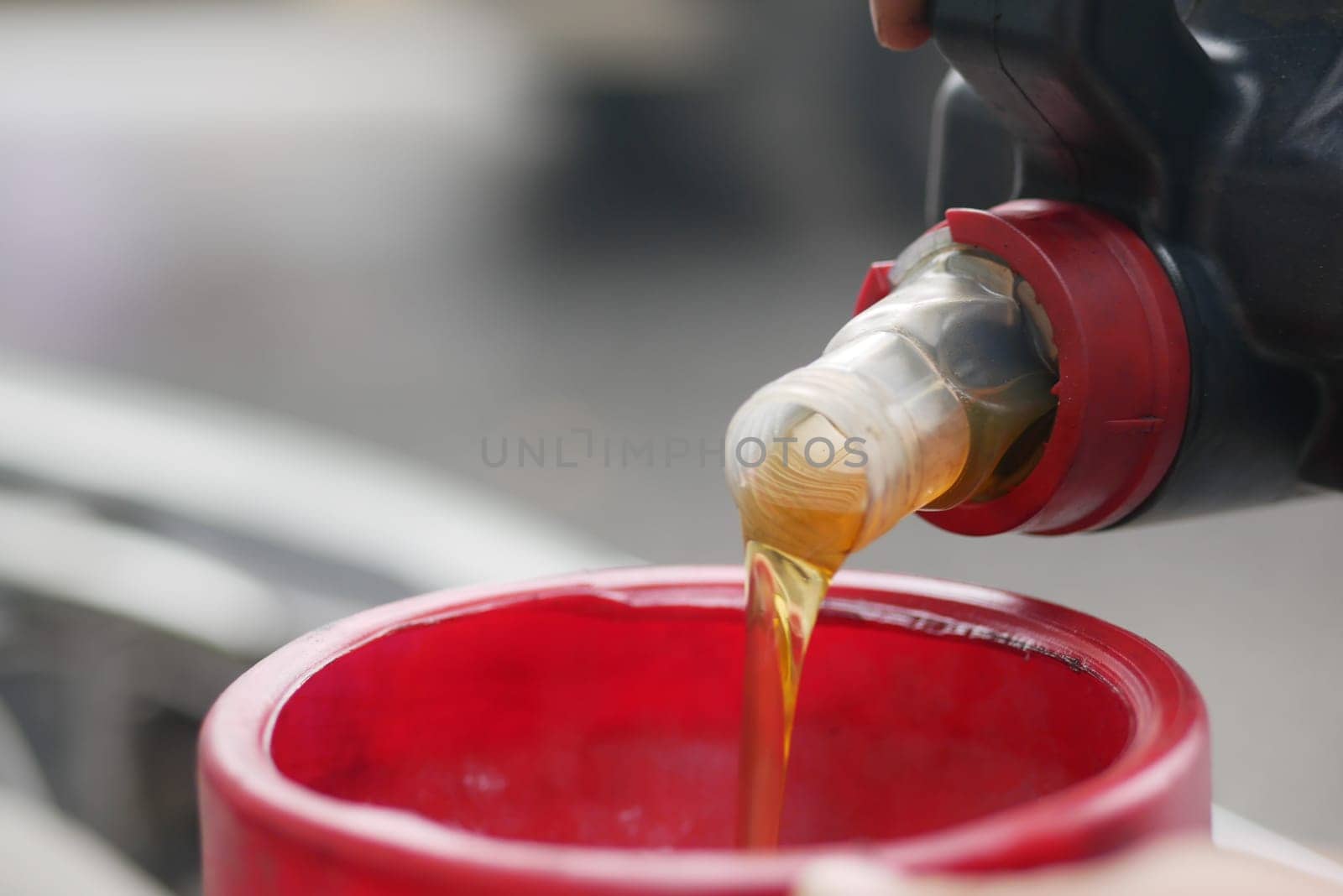 Pouring Liquid Into Red Funnel For Engine Maintenance.