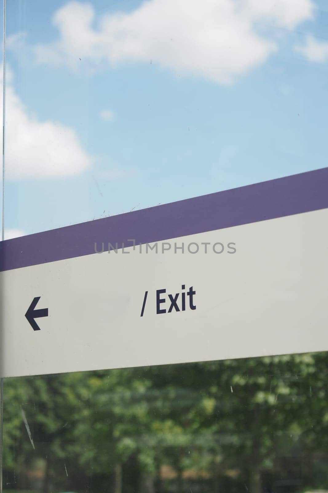A prominently displayed clear exit sign featuring a directional arrow set against a scenic backdrop