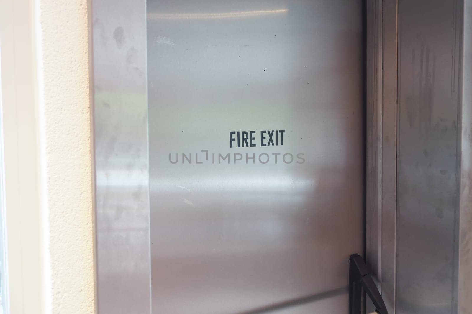 A visible fire exit sign stands out in a busy city near a vibrant yellow taxi cab