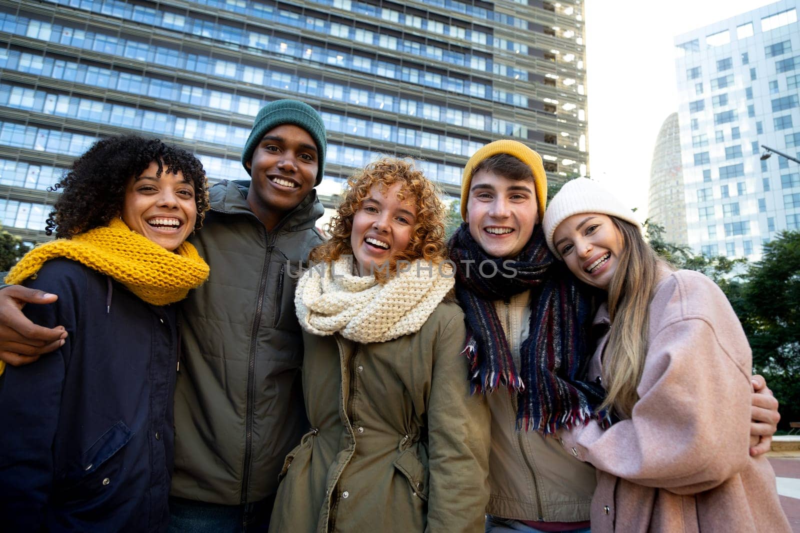 Happy multiracial friends looking at camera wearing winter clothes outdoors Lifestyle portrait concept.