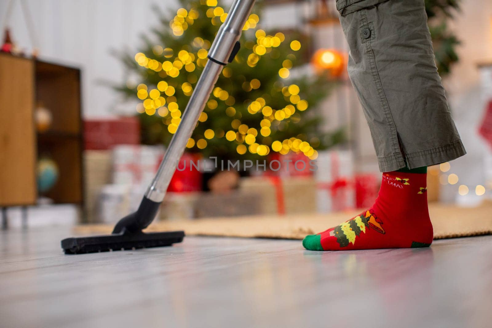 A joyful holiday cleaning scene featuring colorful socks scattered around and a beautifully decorated Christmas tree